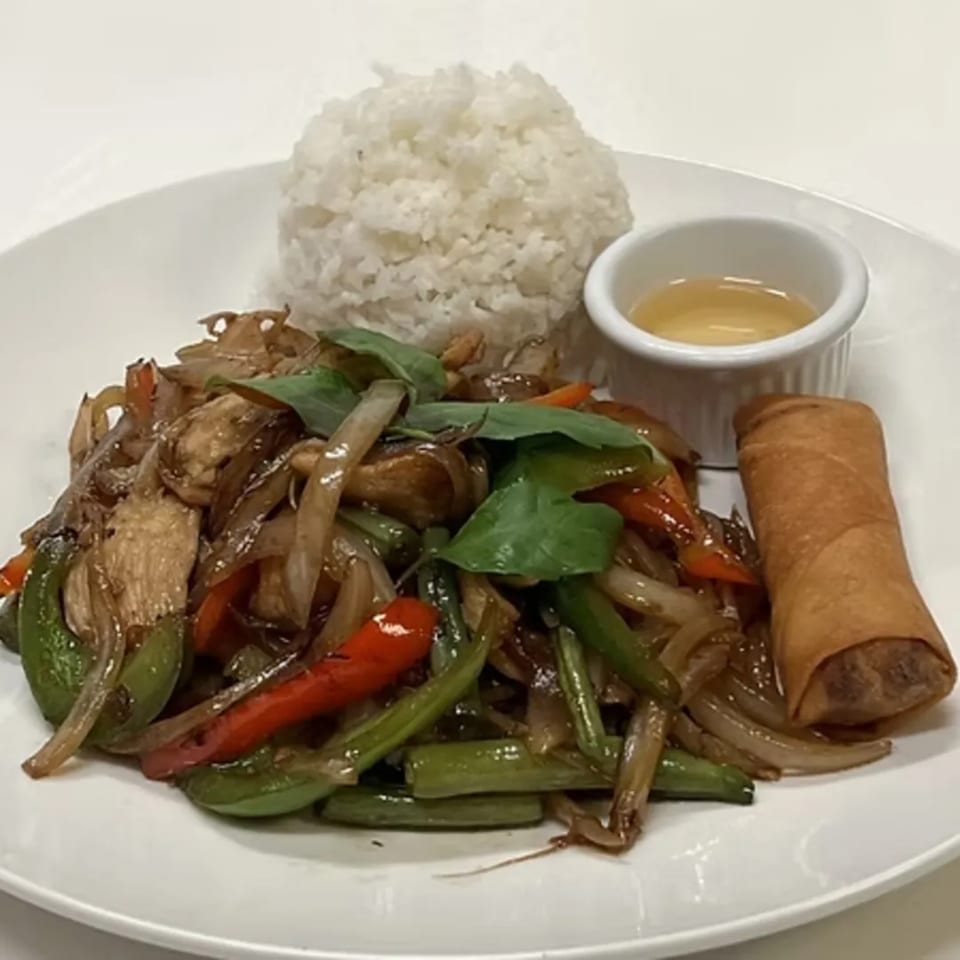 Charm Thai Cuisine's stir-fried dish with chicken, vegetables, rice, a spring roll, and dipping sauce.