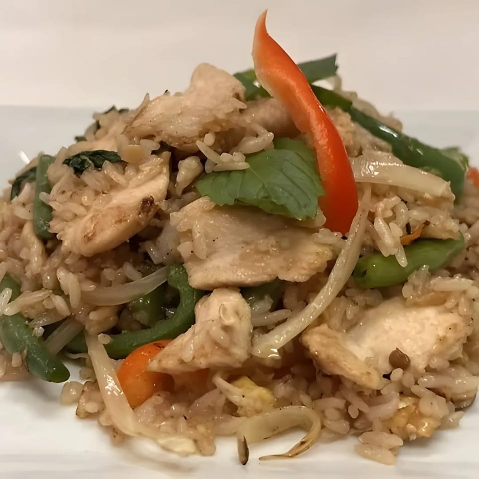 Charm Thai Cuisine's fried rice with chicken, green beans, onions, and a red pepper garnish.