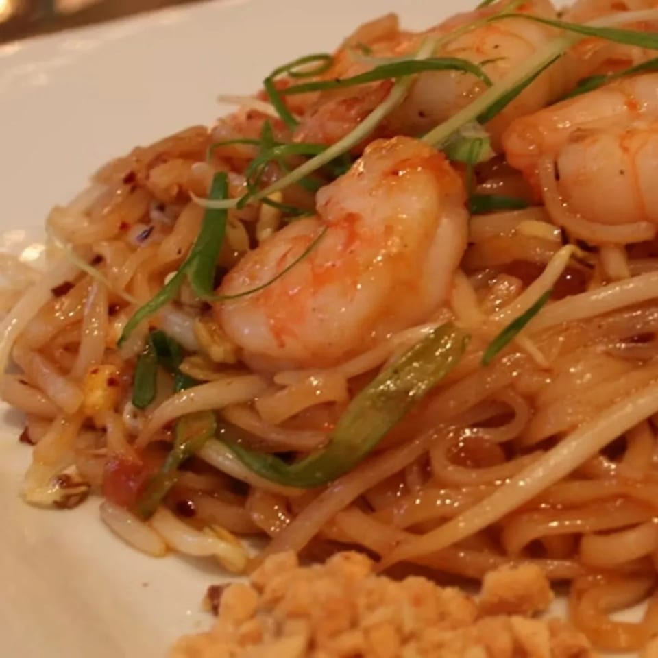 Close-up of Charm Thai Cuisine's Pad Thai with shrimp, noodles, bean sprouts, and peanuts.