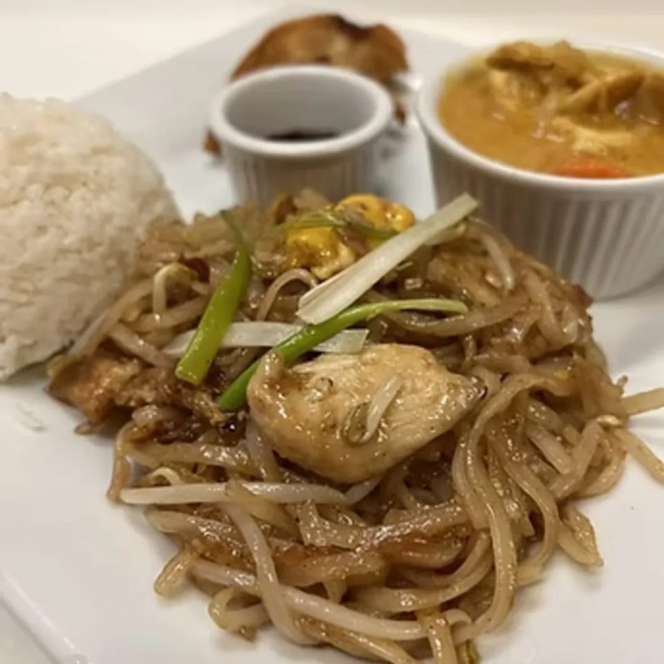 A plate of Charm Thai Cuisine's Pad See Ew with rice, curry, and a dipping sauce.
