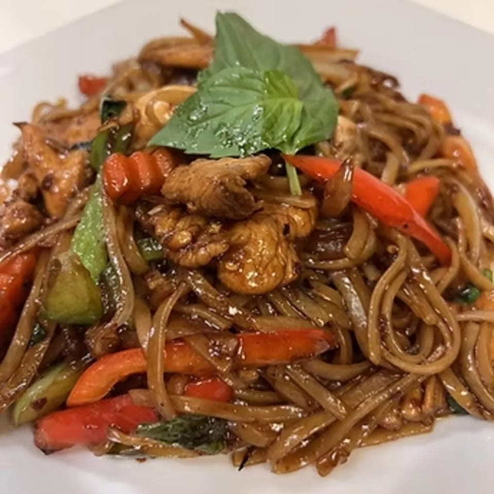 Charm Thai Cuisine's Pad Kee Mao with wide noodles, chicken, red and green bell peppers, and basil.