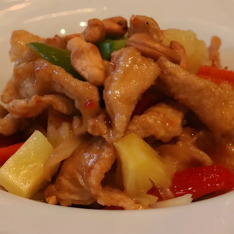 Close-up of Charm Thai Cuisine's sweet and sour chicken with pineapple, cashews, and bell peppers.